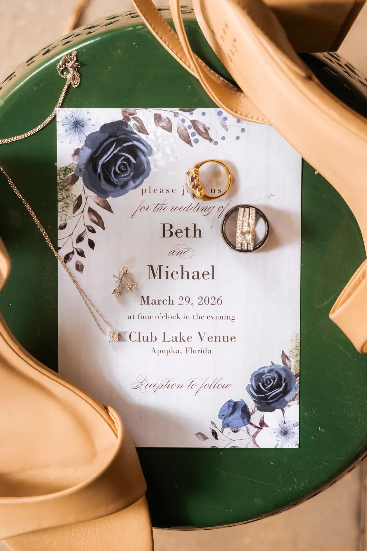 A green table with a white paper on it that says "Bert Michael" and has jewelry on top of the paper.