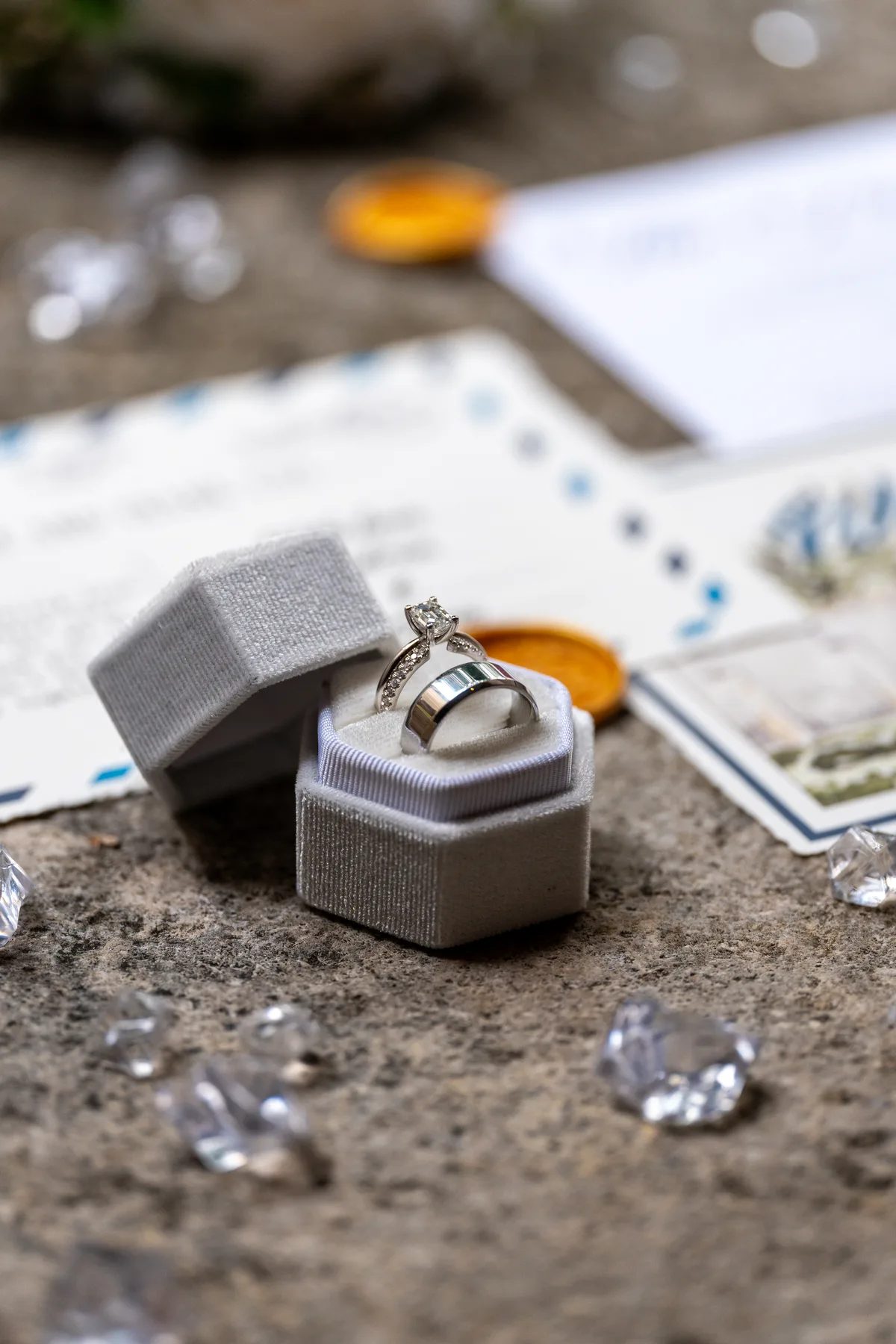a close-up of a wedding ring and engagement ring in an open box surrounded by diamonds.