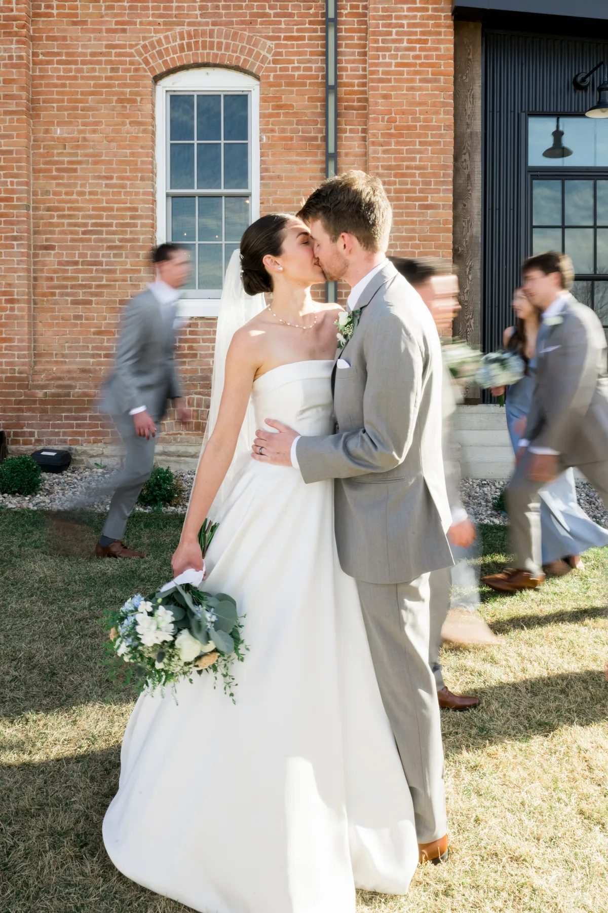 * A couple kissing at a wedding reception.