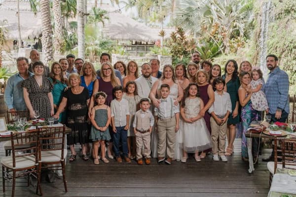 A group of people are posing for a picture outside with their children.